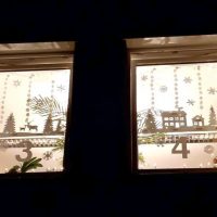 Adventsfenster leuchten am kirchlichen Haus