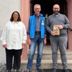 Gemeinsam für „Eine Tasse Menschlichkeit“: Thorsten Bienemann (rechts), Männerbeauftragter des Evangelischen Kirchenkreises Altenkirchen und Initiator der Spendenaktion, mit Günter Papst (Mitte), Leiter der Bahnhofsmission Koblenz, und Nicole Eker, Pfarrerin der Evangelischen Kirchengemeinde Daaden, beim Erntedankgottesdienst in Daaden. Papst stellte dort die Arbeit der Bahnhofsmission vor und warb gemeinsam mit Bienemann um Unterstützung für die Kaffeesammlung. Foto: © Thorsten Bienemann